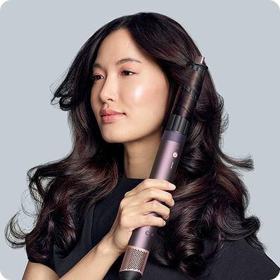 The Dyson Airwrap Co-anda2x multi-styler and dryer curling dark hair